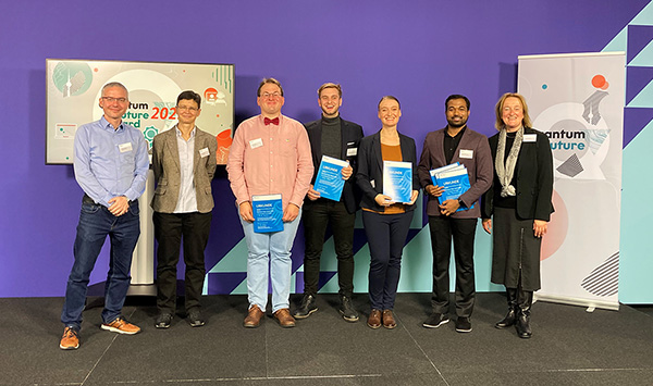 Zu sehen sind die Finalistinnen und Finalisten des Quantum Futur Awards 2022 gemeinsam mit Ina Schieferdecker, Leiterin der Abteilung "Forschung für technologische Souveränität und Innovationen" im BMBF