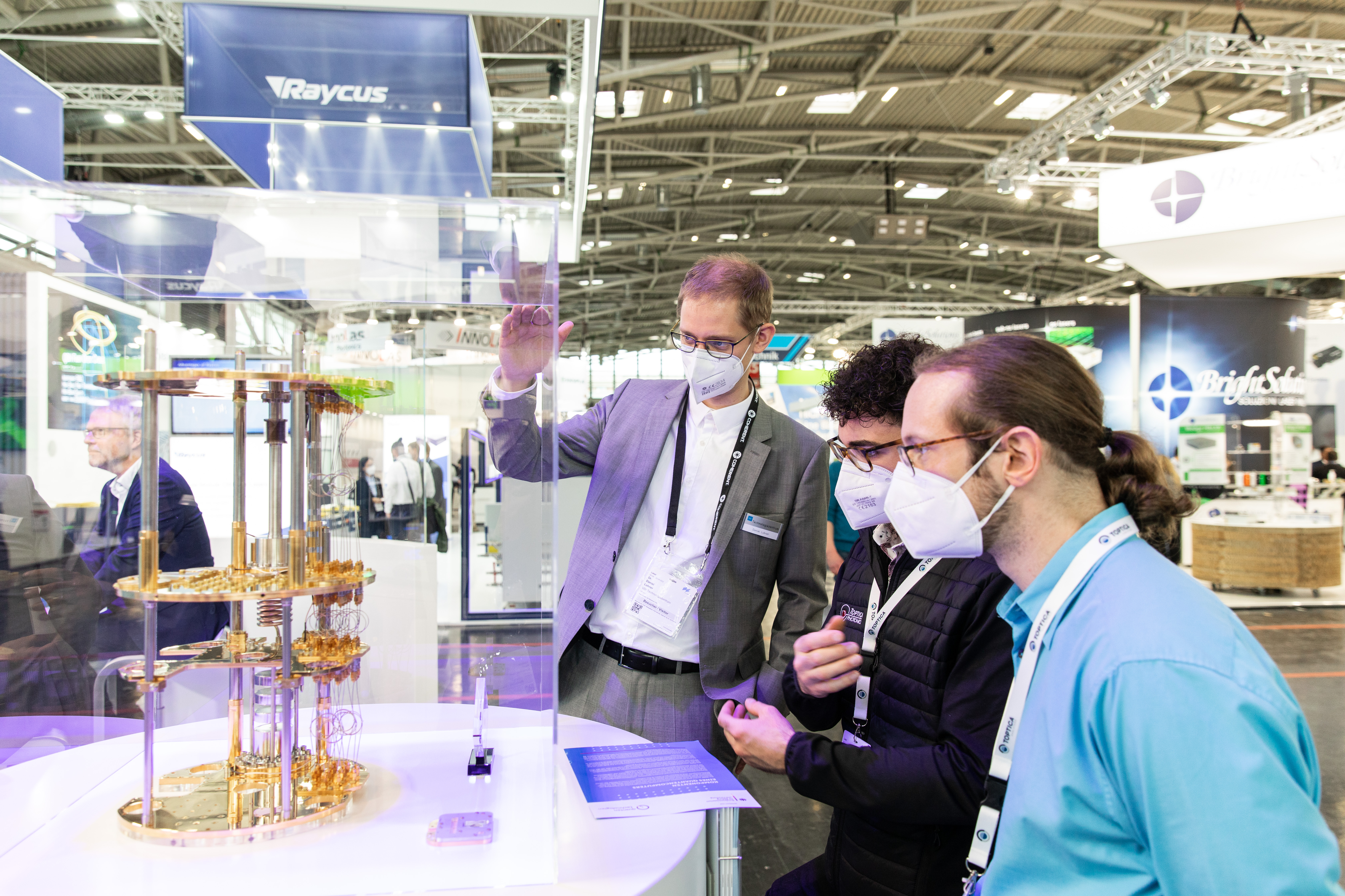 Ein Standmitarbeiter erklärt ein Exponat auf dem BMBF-Messestand auf der LASER World of PHOTONICS 2022 Ende April in München.