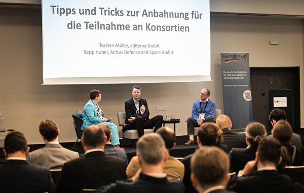 Drei Personen diskutieren auf der Bühne miteinander