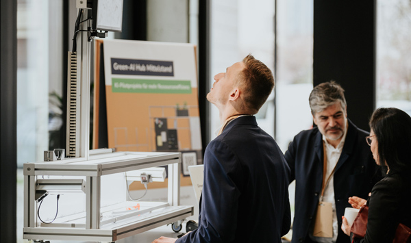 Teilnehmer betrachtet KI-Demonstrator auf dem Green-AI Hub Forum 2025