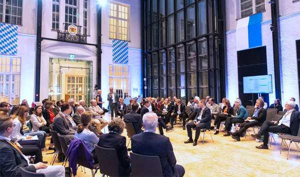 Teilnehmende in einer Fishbowl-Diskussion: Ein kleiner Innenkreis spricht, ein größerer Außenkreis hört zu.