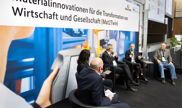 Vier Männer und eine Frau sitzen auf dem Podium und diskutieren.