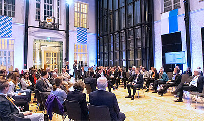 Teilnehmende in einer Fishbowl-Diskussion: Ein kleiner Innenkreis spricht, ein größerer Außenkreis hört zu.